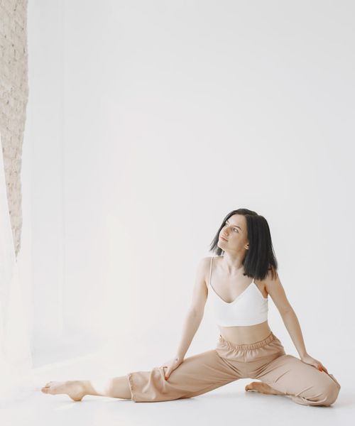 Woman in a calming yoga pose, bathed in soft amber light.
